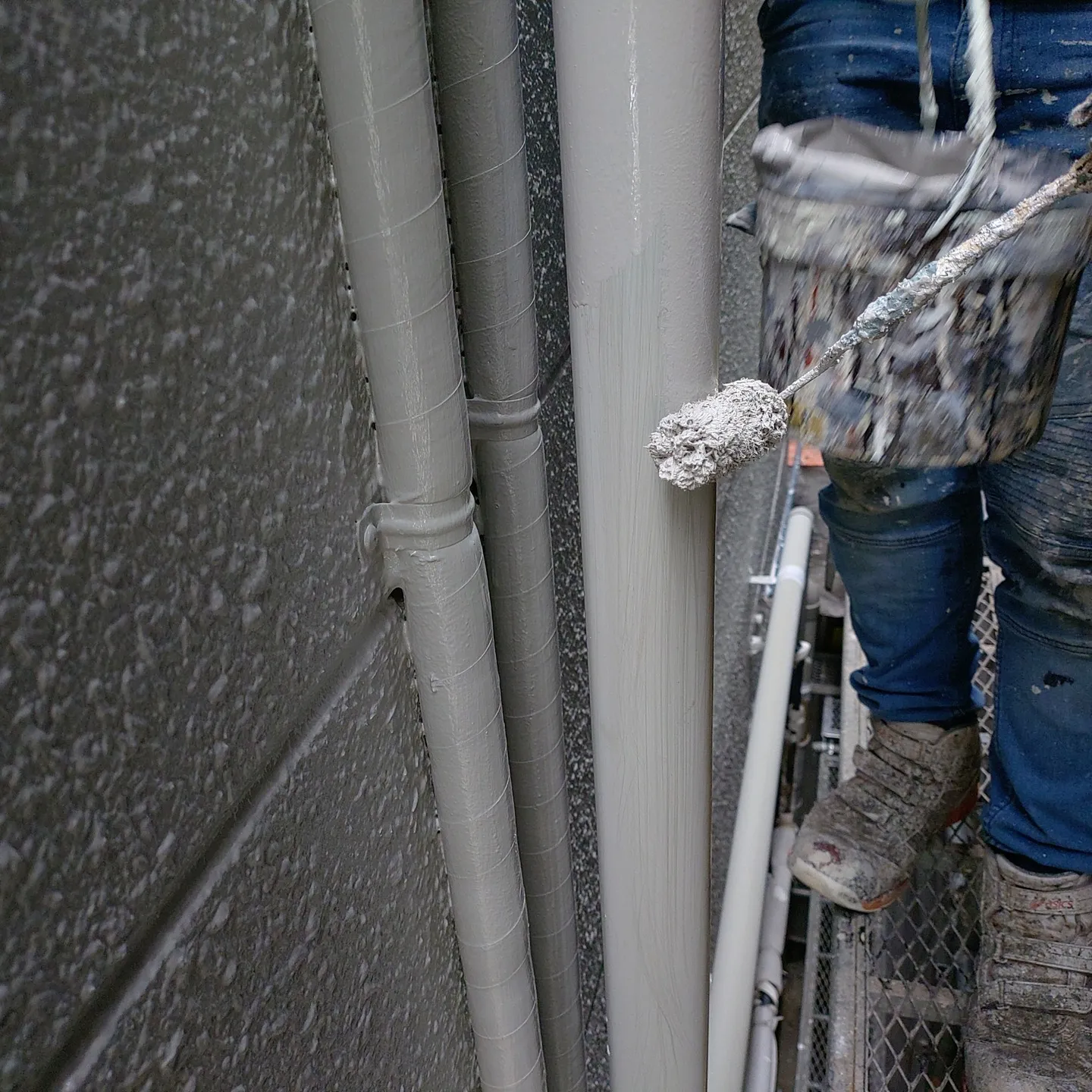 神戸市長田区店舗ビル塗装工事の外壁上塗り作業、付帯部（樋、配...